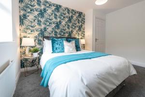 a bedroom with a large bed with a blue blanket at The Croft by Nordstay in Steeton