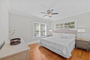 a white bedroom with a bed and a ceiling fan at Flamingo Park Bungalow! WALK TO DOWNTOWN WPB!! in West Palm Beach