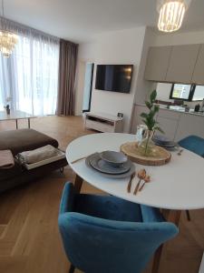 Luxe chalet 79 في روجومبيروك: غرفة معيشة مع طاولة بيضاء وكرسي أزرق