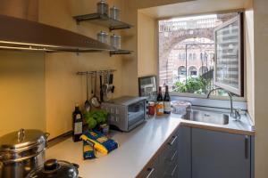eine Küche mit einer Theke mit einem Waschbecken und einem Fenster in der Unterkunft Residenza dei Signori - Italian Homing in Verona