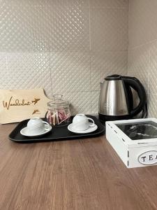 a table with a tray with plates and a coffee maker at Wanderlust Guesthouse in Lamezia Terme