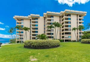 a large building with palm trees in front of it at Polo Beach Club Two Bedrooms - Ground Floor by Coldwell Banker Island Vacations in Wailea