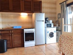 Una cocina con un frigorífico blanco y una lavadora. en Maison confortable avec piscine partagée à Saint-Genies., en Saint-Geniès
