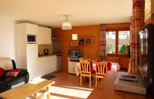 eine Küche und ein Wohnzimmer mit einem Tisch und Stühlen in der Unterkunft Petit nid douillet au coeur de SalvanLes Marécottes in Salvan