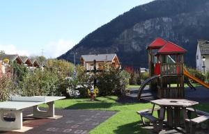 un parque con parque infantil con tobogán y mesa en Petit nid douillet au coeur de SalvanLes Marécottes en Salvan