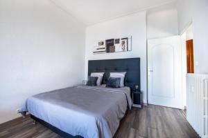 a bedroom with a large bed with a blue headboard at SEA FRONT SUITE - Panoramic View with Terrace - 85 m in Nice