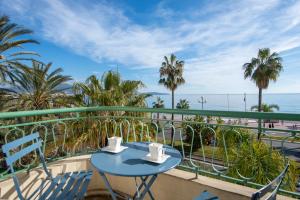 a table and chairs on a balcony with a view of the ocean at SEA FRONT SUITE - Panoramic View with Terrace - 85 m in Nice