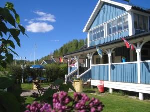 a blue house with flowers in front of it at Wärdshuset Klarälvdalen in Sysslebäck