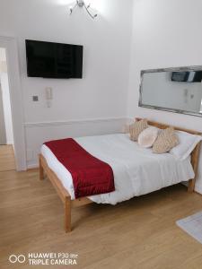 a bedroom with a large bed with a red blanket at Westbourne Terrace in London