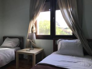 a bedroom with two beds and a window at Mikio House in Kalabaka