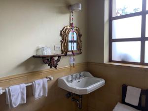 een badkamer met een wastafel, een raam en handdoeken bij Hotel Museo Mayan Inn in Chichicastenango