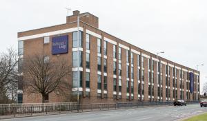 un gran edificio de ladrillo al lado de una carretera en Redwings Lodge Wolverhampton Central, en Wolverhampton