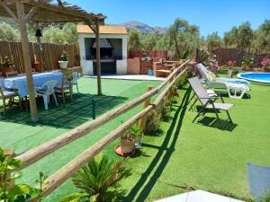 a backyard with a table and chairs and a fence at 5 bedrooms villa with private pool enclosed garden and wifi at Villanueva del Trabuco in Villanueva del Trabuco