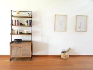 a room with two pictures on the wall and a book shelf at Casa Do Mar - Sea View Beach House - Troia Comporta in Troia