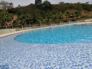 a person swimming in a large blue swimming pool at Santafé Di sole in Santa Fe de Antioquia +7 photos