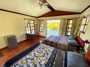 a bedroom with two beds and a table and windows at Brisa Del Mar in Playa Hermosa
