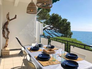 stół z talerzami i kieliszkami na balkonie z widokiem na ocean w obiekcie Un Passo dal Mare w mieście Zoagli