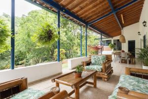 a living room with a table and chairs and windows at Finca La Maria: Recreo y naturaleza (22 personas) in Santa Fe de Antioquia