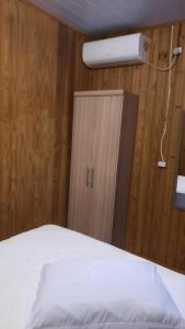 um quarto com uma cama, um closet e uma luz em Lindo Residencial na Praia Itapeva Torres em Torres