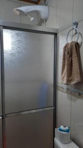 a shower with a glass door in a bathroom at Lindo Residencial na Praia Itapeva Torres in Torres