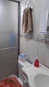 a bathroom with a sink and a toilet and a towel at Lindo Residencial na Praia Itapeva Torres in Torres