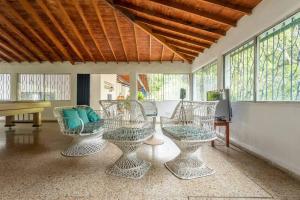 uma sala de estar com quatro cadeiras e um piano em Finca La Maria: Recreo y naturaleza (22 personas) em Santa Fe de Antioquia