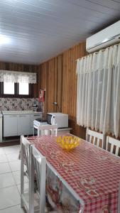 a kitchen with a table and chairs in a room at Lindo Residencial na Praia Itapeva Torres in Torres