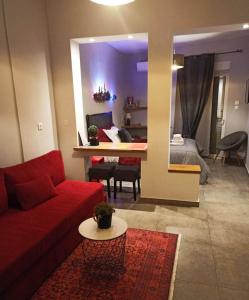 a living room with a red couch and a table at Sandra"s Stay Penthouses with Acropolis View in Athens