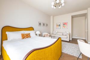 Daplace - Corso Sempione Suites في ميلانو: غرفة نوم بسرير كبير مع اللوح الأمامي الأصفر