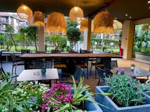 un ristorante con tavoli, sedie e piante in vaso di Hotel Alfieri a Sirmione