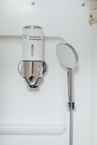 a shower with a shower head in a bathroom at Lisboa F3 Centre-ville Clermont-Fd C in Clermont-Ferrand