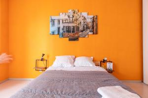 - une chambre dotée d'un lit avec un mur orange dans l'établissement Lisboa F3 Centre-ville Clermont-Fd C, à Clermont-Ferrand