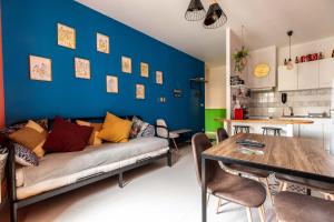 a living room with a couch and a blue wall at Lisboa F3 Centre-ville Clermont-Fd C in Clermont-Ferrand +19 photos