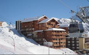 a ski lodge on a snowy mountain with a ski lift at Appartement 6 couchages au pied des pistes à Orcières 2 chambres, balcon et parking couvert in Orcières