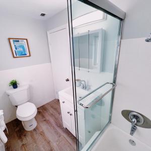 a bathroom with a toilet and a glass shower at The Leeward Apartments By Lowkl in Fort Lauderdale