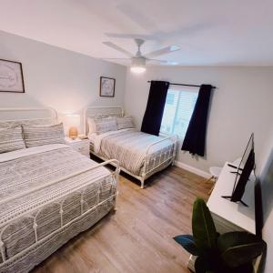 a bedroom with two beds and a television in it at The Leeward Apartments By Lowkl in Fort Lauderdale