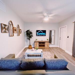 a living room with a couch and a tv at The Leeward Apartments By Lowkl in Fort Lauderdale
