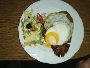 a plate of food with an egg and a salad at Zur alten Eiche in Stepenitz