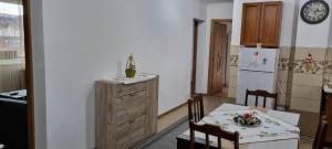 a kitchen with a table and a white refrigerator at Flower Apartment - Edge in Odorheiu Secuiesc