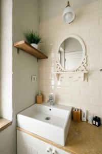 y baño con lavabo blanco y espejo. en Mono Lıfe Alaçatı, en Alacati
