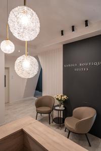 een wachtkamer met 2 stoelen en 2 verlichting bij Karoly Boutique Suites, Best Location by BQA in Boedapest