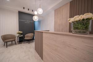 a lobby with a reception desk and two chairs at Karoly Boutique Suites, Best Location by BQA in Budapest
