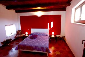 Un dormitorio con una cama y una pared roja. en Angelino Home, en Sulmona