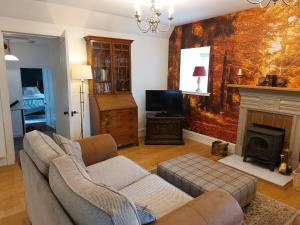 a living room with a couch and a fireplace at Courtyard Cottage - Drum Castle in Banchory