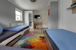 - une chambre avec 2 lits et un tapis coloré dans l'établissement Ferienwohnung Hirmer, à Zirndorf