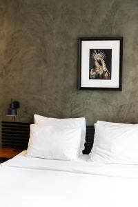 a bed with white pillows and a picture on the wall at Weber Studios in Amsterdam
