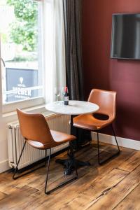 stół i dwa krzesła siedzące obok okna w obiekcie Weber Hotel 397 w Amsterdamie