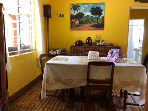 uma sala de jantar com uma mesa com uma toalha de mesa branca em Nat’s place em Treasure Beach