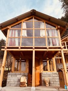 a house with a large glass window on top of it at The Villster Resort in Kasol