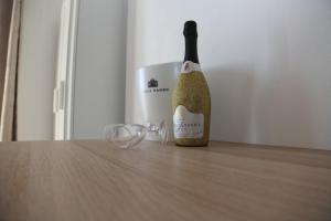 eine Flasche Champagner auf einem Tisch neben der Brille in der Unterkunft B&B La Dimora di Nonno Lucio in Pozzuoli